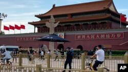 资料照片:北京天安门前一名安全人员在监视过往居民。(2023年6月4日)