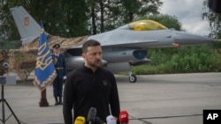 Tổng thống Ukraine Volodymyr Zelenskyy trả lời câu hỏi của phóng viên đứng trước máy bay chiến đấu F-16 của Không quân Ukraine tại một địa điểm không được tiết lộ ở Ukraine, ngày 4 tháng 8 năm 2024.