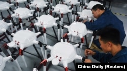 资料照片:中国安徽省安庆的一家无人机工厂的工人在生产线上工作。(2024年5月16日)