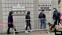 军装警员牵着警犬监察进入西九龙裁判法院大楼,旁听香港壹传媒创办人黎智英国安案的市民 (美国之音/汤惠芸)