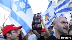 一名示威者手举标语,抗议者在以色列国防部外举行反政府集会,同时对2023年10月7日致命袭击中被绑架的人质表示支持。(2024年9月2日)