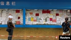 广东深圳市居民在查看一个城中村公告栏上的招工广告。(资料照, 2022年6月1日)