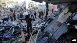 Палестинці в зруйнованій ізраїльськими пострілами будівлі. Смуга Гази, 24 листопада 2023 року