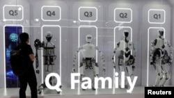 资料照片:参观者在北京举办的世界机器人大会上观看中国科学院自动化研究所展台上展示的人形机器人。(2024年8月21日)