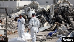 以色列救援人员在南部的斯德罗特市一个被进入以色列国土的哈马斯武装分子的警察局废墟旁寻找死难者,那里曾经展开枪战。(2023年10月11日)