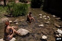 西班牙南部再遭热浪袭击,人们去瓜迪亚罗河里消暑。(2023年7月15日)