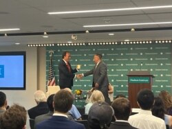 美国智库哈德逊研究所中国中心主任余茂春（Miles Yu)向海曼资本的创始人巴斯(Kyle Bass)2023年7月12日向赠予印有小熊维尼的杯子，巴斯当日发表了关于中国国家主席习近平发动战争时间表的演讲。（美国之音记者薛小山拍摄）