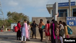 在印度钦奈附近组装iphone手机的富士康工厂大门外,求职者与工厂招聘人员交谈。(2024年4月1日)