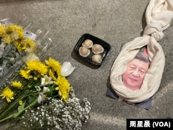 悼念李克强现场,习画像上套了一条围巾做的绞索和一盒包子。(周星晨)