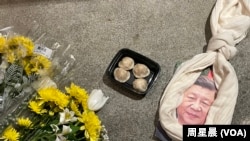 悼念李克强现场,习画像上套了一条围巾做的绞索和一盒包子。(周星晨)