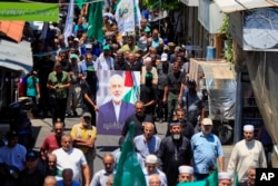 在黎巴嫩南部港口城市提尔的巴勒斯坦难民营,哈马斯成员举着哈马斯领导人伊斯梅尔·哈尼亚 (Ismail Haniyeh) 的画像抗议他被刺杀。(2024年7月31日)