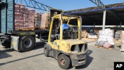 联合国和红新月会的工作人员在加沙地带一个仓库卸下准备发放给巴勒斯坦人的救济物资。(2023年10月23日)