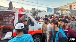 资料照片:2023年11月3日,人们聚集在加沙城希法医院前一辆据称在以色列袭击中受损的救护车周围。(法新社照片)