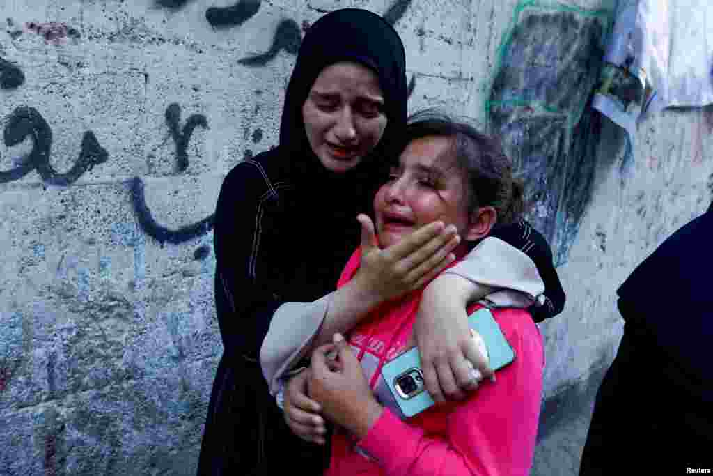 Con gái của Zakaria Abu Maamar, một thành viên của văn phòng chính trị của Hamas, được vỗ về khi em khóc trong đám tang của cha mình, sau khi ông này bị hạ sát trong một cuộc không kích, ở Khan Younis, phía nam Dải Gaza, ngày 10 tháng 10 năm 2023.  
