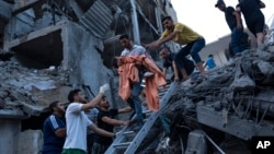 以色列空袭后,巴勒斯坦人从一栋民居中救出一个小女孩。(2023年10月10日)