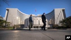 资料照片:戴着口罩的行人从北京的中国人民银行前走过。(2023年3月3日)