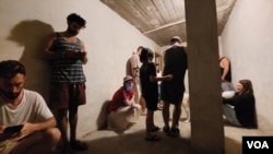 10月16日特拉维夫市中心, 警报声响起后,住在公寓楼的人们躲进楼底掩体里躲避火箭弹 (美国之音/唐丹鸿)