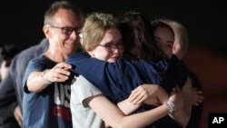 自由欧洲电台记者阿尔苏·库尔马舍娃(Alsu Kurmasheva,右二)从俄罗斯获释后,在马里兰州安德鲁斯空军基地与丈夫帕维尔·布托林(Pavel Butorin,左)以及女儿米里亚姆·布托林(Miriam Butorin)和比比·布托林(Bibi Butorin)拥抱。(2024 年 8 月 1 日)