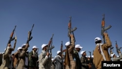 胡塞武装分子在也门萨那附近参加一场抗议美国领导的对胡塞目标袭击行动的集会。(路透社2024年1月25日)