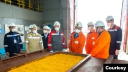 资料照片:哈萨克斯坦国家原子能工业公司的照片显示该公司的工作人员在该国南部的采矿设施中查看铀黄饼。(2022年4月22日)