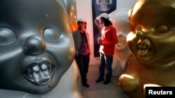 中国艺术家高氏兄弟在他们位于北京的工作室里走过他们的一些“毛小姐”作品。(路透社:2007年10月16日)