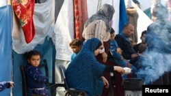 一名逃离家园的巴勒斯坦妇女在一所联合国开办的学校里为家人做饭。(2023年12月4日)