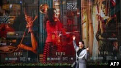 一名女子在电视剧《繁花》剧照前留影。（2024年1月7日）