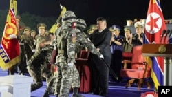 在朝鲜政府提供的这张照片中,朝鲜领导人金正恩在平壤举行的向前线部队交付250台具备核能力的导弹发射器仪式上将一面军旗交给士兵。(2024年8月4日)