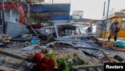 俄占城市顿涅茨克的一个市场遭到炮击后,一束纪念死难者的鲜花摆放在废墟上。(2024年1月22日)