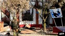 ရှမ်းပြည်မြောက်ပိုင်း နမ်းခမ်းမြို့က ရဲစခန်းရှေ့ အစောင့်ချထားတဲ့TNLA- တအာင်း ပလောင်ဝ် တိုင်းရင်းသားလက်နက်ကိုင်တပ်ဖွဲ့ဝင်တဦး။ (နိုင်ဝင်ဘာ ၉၊ ၂၀၂၃)