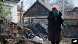 FILE - Lyubov Stasovskaya, 86, wipes tears in the backyard of her house in Donetsk, eastern Ukraine, Oct. 28, 2014. Donetsk, which has lost about 400,000 of its 1 million pre-war population, is bracing to a winter ahead.