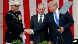 川普总统在阿灵顿公墓圆形剧场发表讲话。他与参联会主席邓福德上将握手,中间站立者是国防部长马蒂斯。(2017年5月29日)