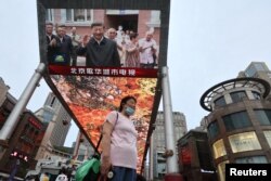 资料照:北京街头的大屏幕电视报道中国领导人习近平在新疆参观视察。(2022年7月15日)