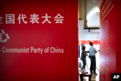 采访中共二十大的记者们站在北京一家酒店大堂。(2022年10月14日)