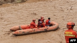 中国甘肃省的救援人员乘坐小艇在洪水中行进。(2022年7月16日)