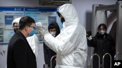 Một hành khách được đo thân nhiệt ở cửa ga tàu điện ngầm ở Bắc Kinh hôm 26/1.