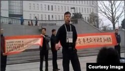 袁冬等人2013年3月31日在北京西单展示反腐横幅呼吁官员公示财产。后来袁冬被判刑一年半(微博图片)