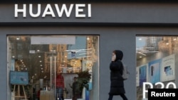 资料照:一名女子走过乌克兰首都基辅市中心的一家华为商店。(2019年11月11日, 路透社)