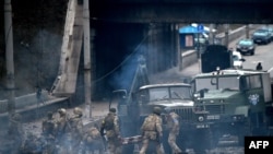 2022年2月26日,在乌克兰首都基辅与突袭的俄罗斯军队交战后,乌克兰军人在搜寻未爆炸的炮弹。