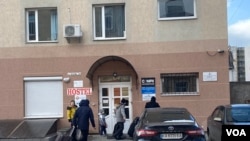 现在,每小时都有更多的撤离者出现在市中心,他们拉着轮子,艰难地背着鼓鼓的背包。他们来到市中心,看看能不能找到住处(美国之音德特默拍摄)。