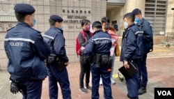 防疫二人限聚令下,社民连主席陈宝莹与成员余炜彬在西九龙裁判法院外结束请愿行动后,数名警员随即上前将他们包围,要求搜查随身物品 (美国之音/汤惠芸)