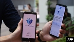 新加坡政府科技局工作人员展示新加坡为应对新冠病毒疫情新推出的接触者追踪智能手机APP(2020年3月20日),这款APP使用蓝牙技术。