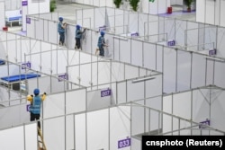 资料照:中国广东广州的工人在琶洲国际会展中心为新冠疫情修建方舱。(2022年4月10日)