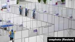 资料照:中国广东广州的工人在琶洲国际会展中心为新冠疫情修建方舱。(2022年4月10日)