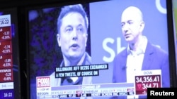 纽约证交所电视屏幕上显示的特斯拉首席执行官马斯克(左)亚马逊公司董事长兼首席执行官贝索斯的画像。(2022年4月11日)