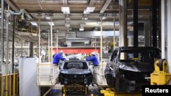 上汽集团在临港的汽车生产基地里,工人在生产线上工作。(2022年4月23日)