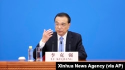 中国总理李克强在北京人大会堂全国人大会议闭幕后举行的记者会上讲话的照片,这是李克强最后一次作为总理出席一年一次的人大记者会。(2022年3月11日)