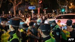 2022年11月27日,在上海乌鲁木齐路举行抗议的人群与警察。(法新社)