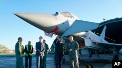 英国首相里希·苏纳克(前排左起第二)2022年11月9日访问英国皇家空军基地康宁斯比时同有关人员交谈。英国刚刚宣布将同意大利和日本联合研制下一代战机。