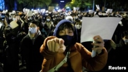 资料照:北京民众走上街头举起白纸游行抗议当局严厉的防疫封控措施。(2022年11月27日)